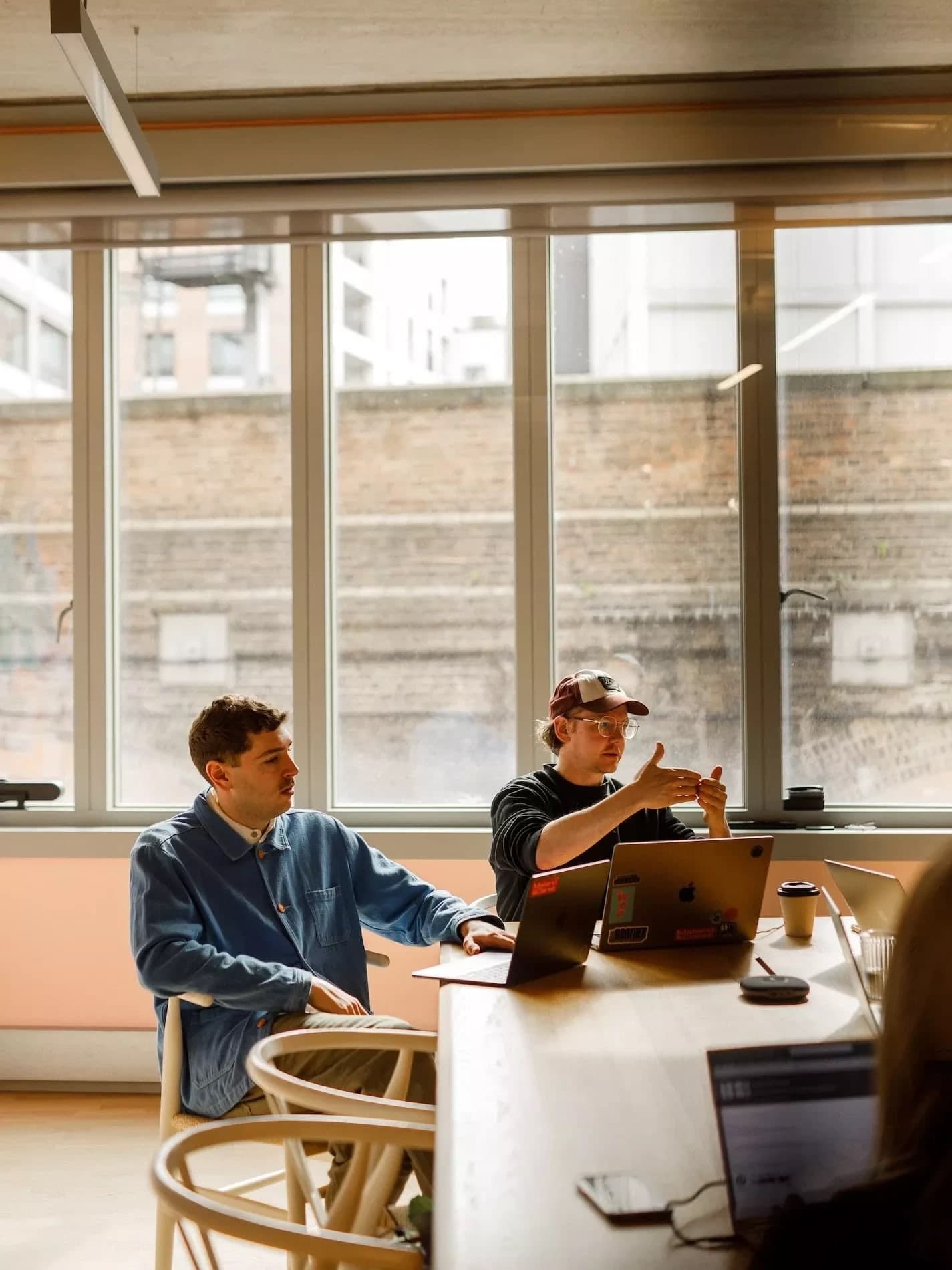 Colleagues discussing work in a sunlit meeting room